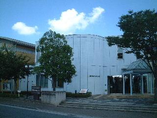 街路樹の奥に見える壁幸松地区公民館の外観の写真（「幸松地区公民館」のページへリンク）